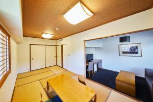 a living room with a wooden table and a desk at Shiki Resort Villa Hakone 80 in Hakone
