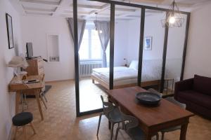 a living room with a table and a bed and a room at Albergo Diffuso Porrentruy in Porrentruy