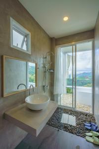 a bathroom with a sink and a large window at Phu Phop Kham in Ban Huai Khai