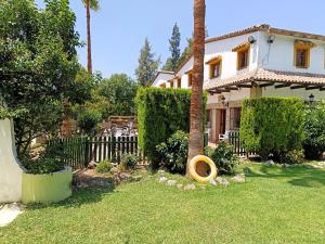 a house with a fence and a tree in the yard at Hotel Restaurante Las Buitreras in El Colmenar