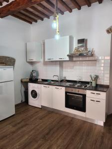 kuchnia z białymi szafkami, zlewem i zmywarką do naczyń w obiekcie ANCORA GIGLIO home w mieście Giglio Porto