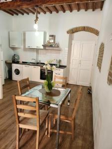 een eetkamer met een tafel en stoelen en een keuken bij ANCORA GIGLIO home in Giglio Porto