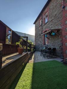 una terraza con mesa y sillas en un edificio en Cwmcarn Hotel & Bunkhouse, en Cwmcarn