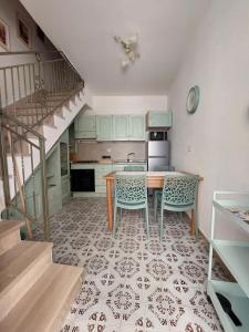a kitchen with a table and chairs and a staircase at Da Zia Dorina in Siniscola