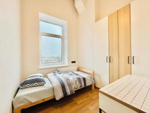 1 Schlafzimmer mit 2 Betten und einem Fenster in der Unterkunft Respublikos LOFT Forentinn in Panevėžys