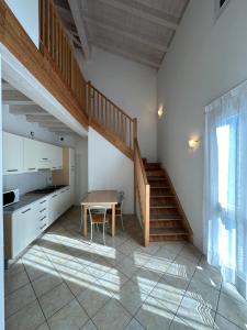 a kitchen with a table and a staircase in a room at RESIDENCE STEFANIA ATTICI SU 2 LIVELLI - AGENZIA COCAL in Caorle