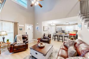a living room with leather furniture and a kitchen at Old Woodland Station in Clarksville