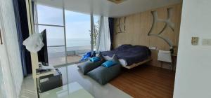 1 dormitorio con cama, sofá y TV en Luxtalay beachhouse villa en Ban Thung Makham