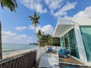 Luxtalay beachhouse villa في Ban Thung Makham: منزل على الشاطئ مع نخلة