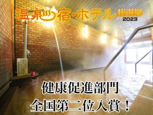 a room with a water fountain in a brick wall at 吸う温泉 湯治の宿 竜王ラドン温泉 湯ーとぴあ in Kai