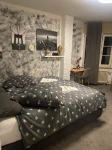 a bedroom with a black and white comforter on a bed at Landgasthof im Schwarzwald ideal für Wanderer & Biker in Pforzheim