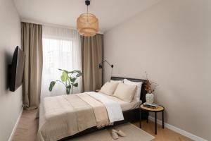 a bedroom with a bed and a window and a table at Apartments Wroc'LOVE by me & Mosiężna & Free Garage & Self Check in 24H in Wrocław