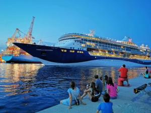 a group of people sitting on the shore near a cruise ship at Apartma Sia Koper in Koper