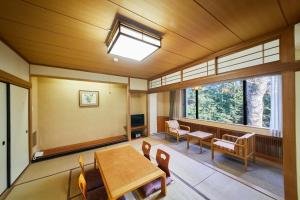 a dining room with a table and chairs and windows at Shiki Resort Hakone Wanoka in Hakone
