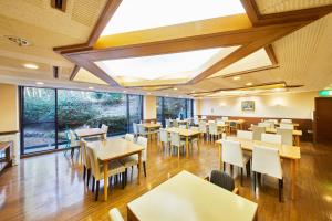 a restaurant with tables and chairs and a large window at Shiki Resort Hakone Wanoka in Hakone