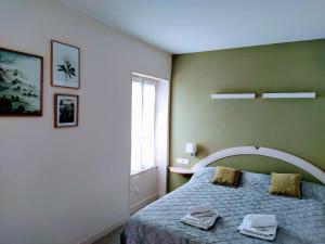 1 dormitorio con 1 cama con 2 toallas en Hôtel restaurant Notre Dame, en Orcival