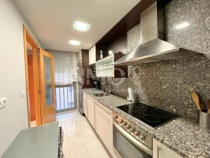 a kitchen with granite counter tops and a stove at Moderno apartamento con piscina y parking 162B - INMO22 in Cambrils