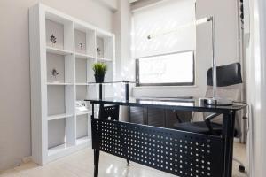 Modern Luxury 2 Bedroom Apt in Agios Dimitrios في أثينا: مكتب به مكتب أسود وكرسي