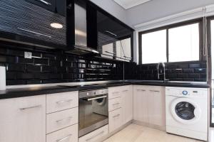 a kitchen with white cabinets and a washer and dryer at Modern Luxury 2 Bedroom Apt in Agios Dimitrios in Athens