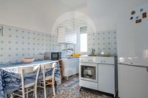 a kitchen with a stove and a table with chairs at Villa Martina - Spiaggia a 190m in Torre Lapillo