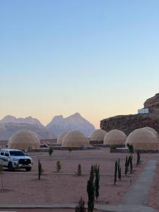 un estacionamiento con domos en un desierto con montañas en Rozan Luxury Camp Wadi Rum en Wadi Rum