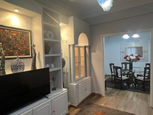 a living room with a television and a dining room at Amplio y céntrico piso con patio. in A Coruña