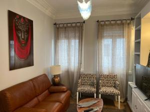 a living room with a leather couch and a chair at Amplio y céntrico piso con patio. in A Coruña