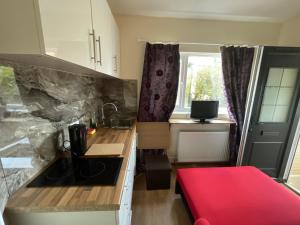 - une petite cuisine avec un canapé rouge dans une chambre dans l'établissement Livadia House at St Leonards on Sea, à St. Leonards
