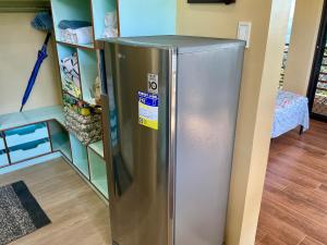 a stainless steel refrigerator in a kitchen next to a shelf at Aguanga Cabin at Threesome Cafe in Cebu City