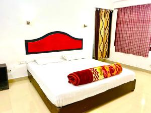 a bedroom with a bed with a red headboard at Glen Brook Home Stay in Munnar