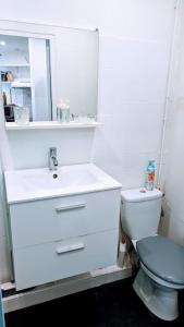 a white bathroom with a toilet and a sink at 2P agréable et spacieux proche du Stade de France! in Saint-Denis