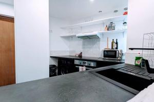 a kitchen with a counter top and a microwave at 2P agréable et spacieux proche du Stade de France! in Saint-Denis
