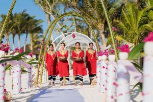 a group of people walking down the aisle at a destination wedding at OBLU SELECT Sangeli - Premium All Inclusive with Free Transfers in North Male Atoll