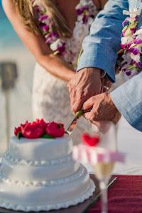 Braut und Bräutigam schneiden ihre Hochzeitstorte in der Unterkunft OBLU SELECT Sangeli - Premium All Inclusive with Free Transfers in Nord-Malé-Atoll