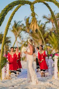 a bride is standing under an arch on the beach at OBLU SELECT Sangeli - Premium All Inclusive with Free Transfers in North Male Atoll