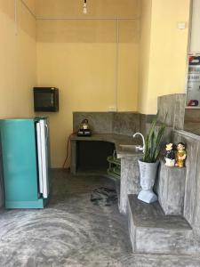 a kitchen with a refrigerator and a table with a plant at Heena Villa in Matara