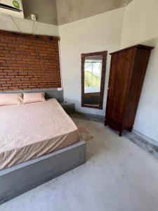 a bedroom with a bed and a mirror and a brick wall at Heena Villa in Matara