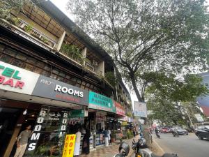 a busy city street with shops and people on motorcycles at Rio Rooms Calicut Near Mims Hospital in Kozhikode