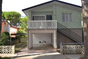 uma pequena casa com uma varanda e uma mesa em Dolomiti em Bibione