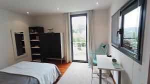 1 dormitorio con cama, escritorio y ventana en Argiazblai en Plentzia