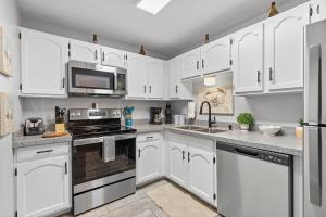 a kitchen with white cabinets and a stove top oven at Sea Coast Gardens II 115 in New Smyrna Beach