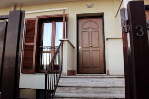 una porta marrone su una casa con scale di Villetta fronte Metro C, parcheggio, Wi-Fi, A/C a Roma
