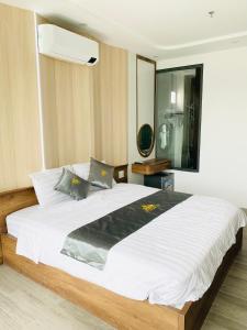 a bedroom with a large bed with white sheets at T&T Luxury Hotel in Quy Nhon