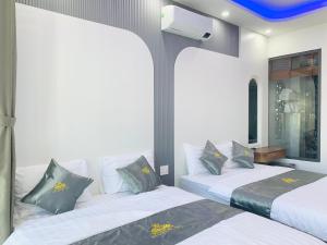 two beds in a room with two at T&T Luxury Hotel in Quy Nhon
