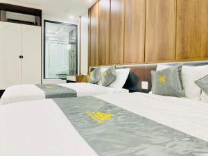 two beds in a hotel room with white sheets at T&T Luxury Hotel in Quy Nhon +61 photos