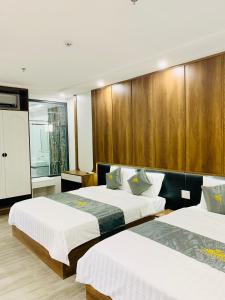 two beds in a hotel room with wooden walls at T&T Luxury Hotel in Quy Nhon