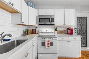 a kitchen with white cabinets and a white stove top oven at Flagler Suites 3 in New Smyrna Beach