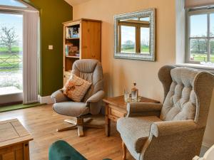 a living room with two chairs and a table at Southview Barn in Barnard Castle