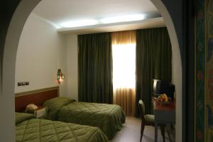 A bed or beds in a room at Hotel Chellah