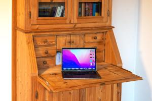einen Laptop auf einem hölzernen Schreibtisch in der Unterkunft Breubergblick, Stylisches Apartment in Breuberg in Breuberg